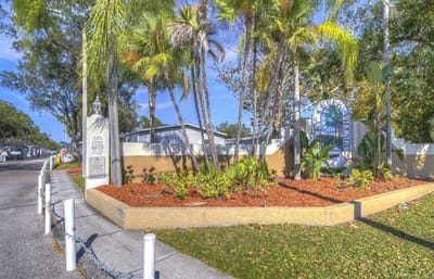 Entrance of a senior living facility with palm trees.