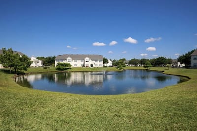 A serene outdoor view of the facility's pond and buildings