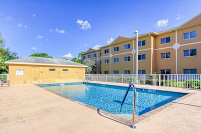 Outdoor pool area with a building in the background