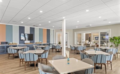 Bright dining area with tables and chairs arranged.
