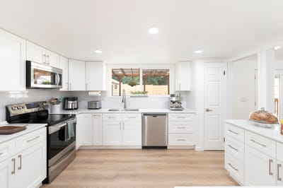 Bright modern kitchen featuring white cabinets and appliances