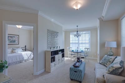 Bright interior of a senior living apartment with living area and dining space