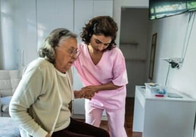 Caregiver assisting an elderly resident indoors.