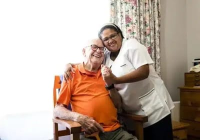 A staff member and resident smiling together