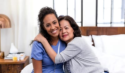 Nurse and resident sharing a warm embrace.