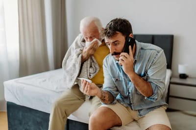 A senior man and a caregiver in a room.
