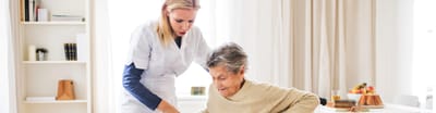 Caregiver assisting an elderly resident indoors.