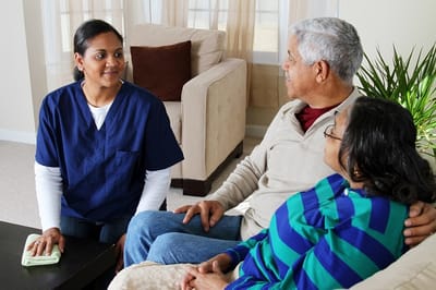 Caregiver interacting with seniors in a common area.