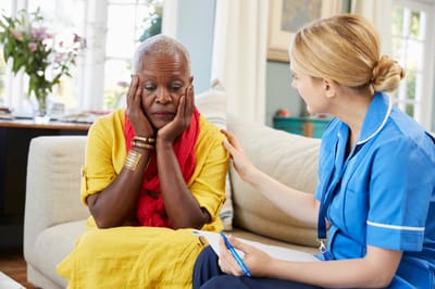 Caregiver comforting a resident in a cozy living room