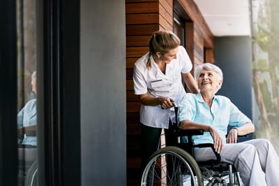 Staff assisting a resident in a wheelchair