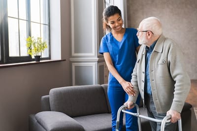 Caregiver assisting an elderly resident indoors.