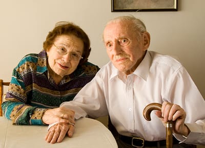 Elderly couple sitting together at a table.