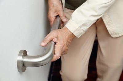 Close-up of a senior's hand on a safety bar.