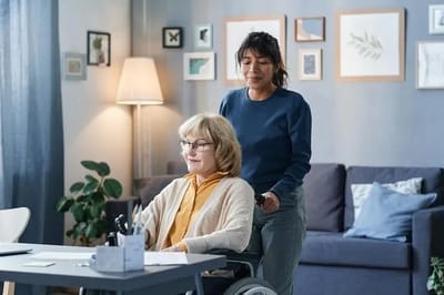 Caregiver assisting a resident in a cozy living space.