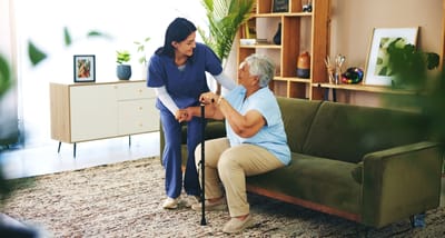 Staff assisting a resident in a cozy living area.