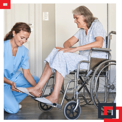 Caregiver assisting elderly woman in wheelchair