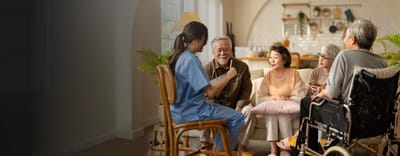 Residents engaging in conversation with a caregiver.