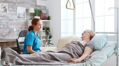 Nurse talking to a resident in a room.