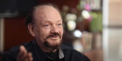 A man speaking in a warm, inviting setting.
