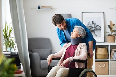 Caregiver interacting with senior woman in a wheelchair