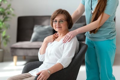 Senior resident with caretaker in a cozy setting.