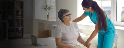 Resident interacting with a caregiver in a cozy room.