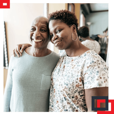 Two women smiling together in a welcoming room