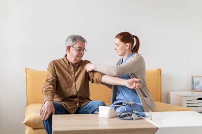 Nurse checking blood pressure of a senior man.