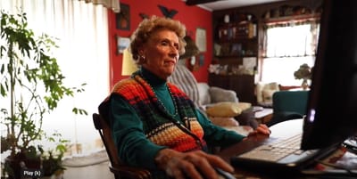 Senior resident using a computer in a cozy interior.