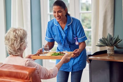Staff serving a meal to a resident