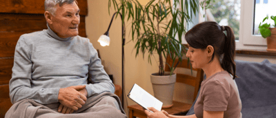 Caregiver reading to a senior resident