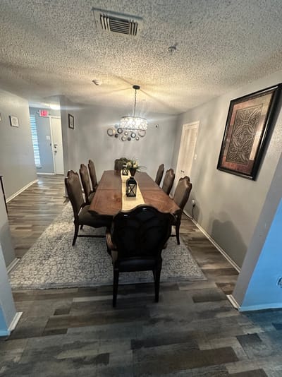 Dining area with a long wooden table and chairs.