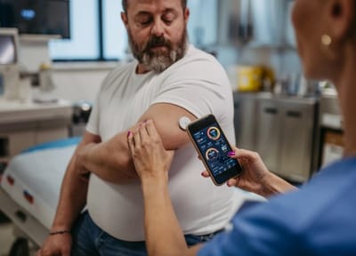 Healthcare professional assisting a patient with a device.