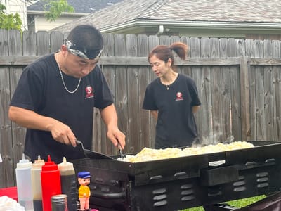 Two staff members cooking outdoors at the facility.