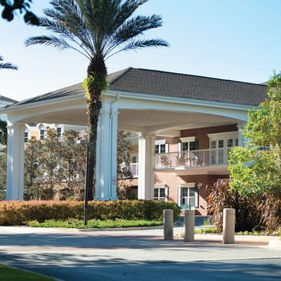 Exterior view of a senior living facility with palm trees