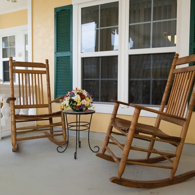 Rocking chairs with a flower arrangement on a porch