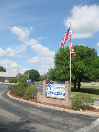 Entrance sign for Park Place Apartments with flags