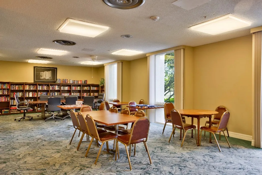 Common area with tables and bookshelves in a warm setting