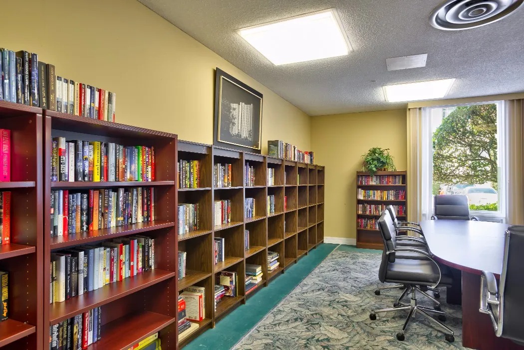 Interior view of a library with bookshelves and a table