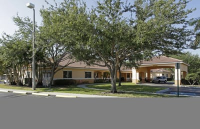 Exterior view of a senior living facility with landscaping