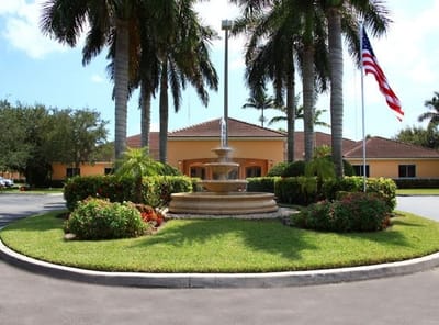 Entrance of assisted living facility with fountain and palm trees