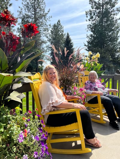 Residents relaxing in colorful chairs surrounded by flowers