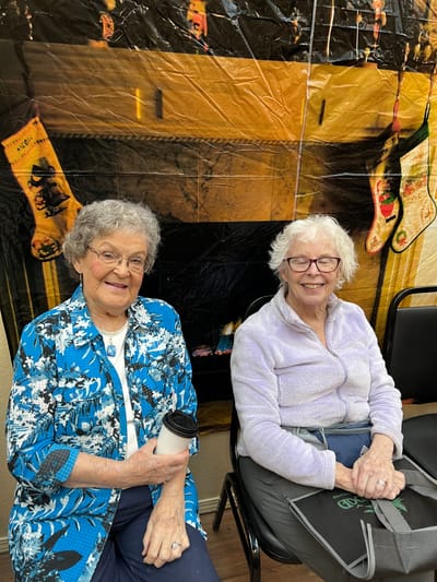Two smiling residents enjoying a cozy indoor setting