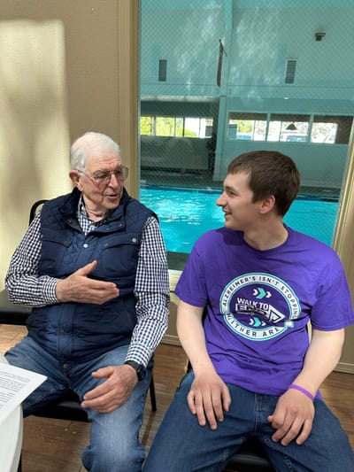 Two residents engaging in conversation near a pool.