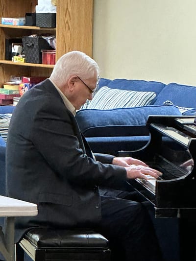 Resident playing piano in a common room