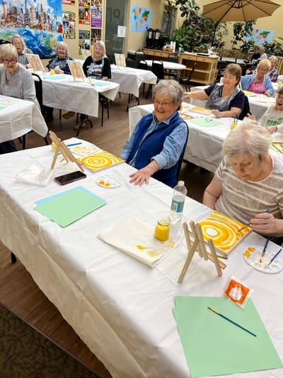Residents participating in a painting activity in a common area