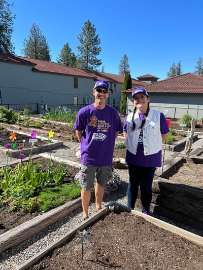 Two staff members in a community garden area