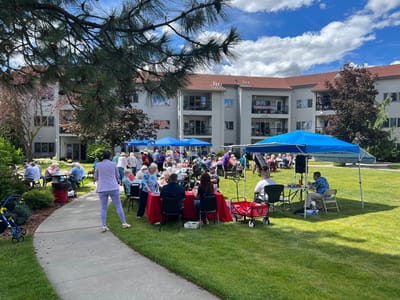 Residents enjoying an outdoor community event with tents and music