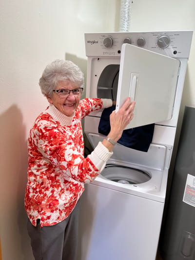 Resident doing laundry in a bright laundry room
