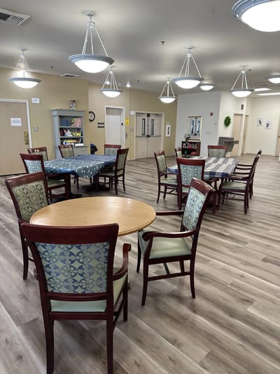 Common area with tables and chairs in a bright room